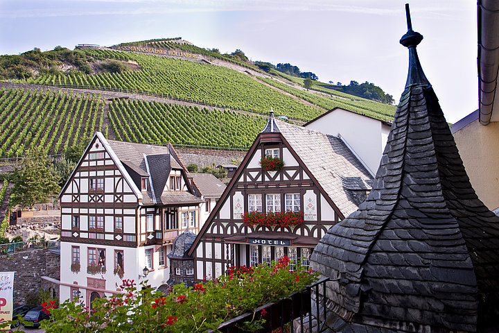 Das Hotel Berg's Alte Bauernschänke befindet sich in einem Fachwerkhaus mit üppig blühenden roten Geranien an den Fenstern.